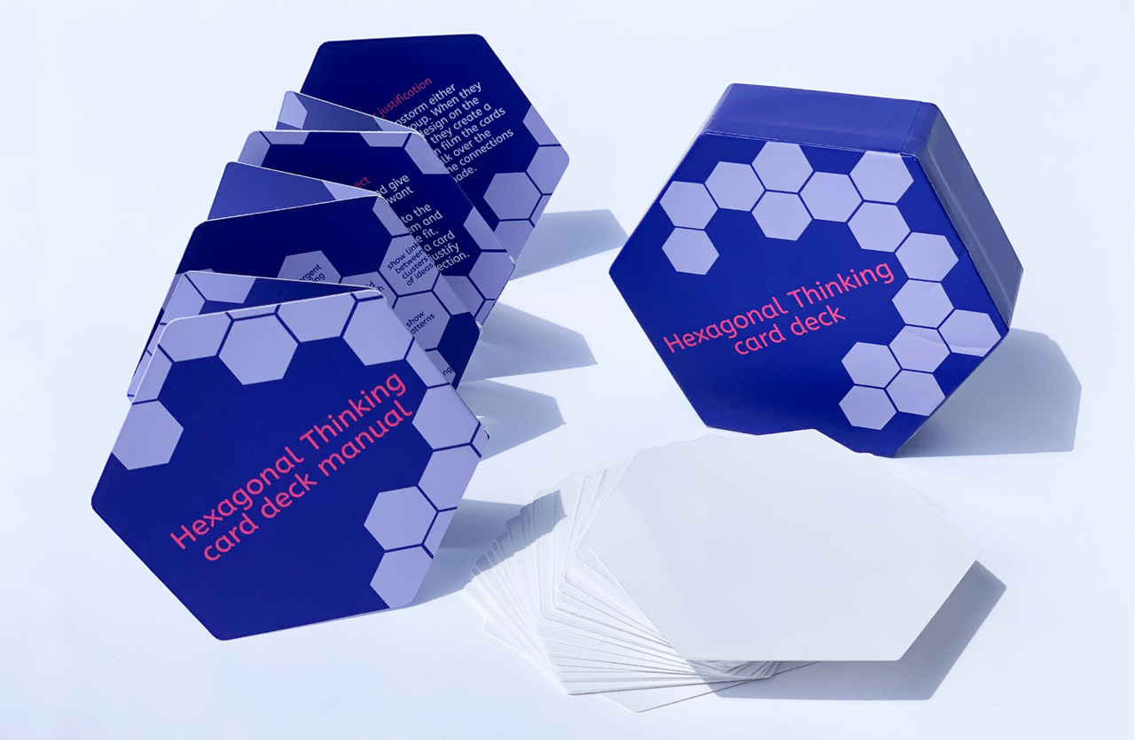 Hexagonal Thinking deck and booklet on a table